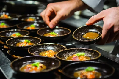 Chef Plating Gourmet Appetizers In Professional Kitchen