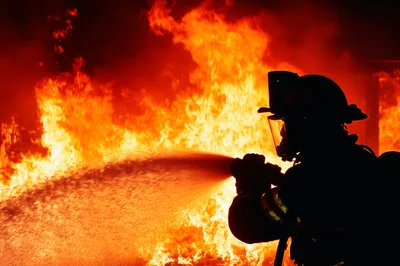 Firefighter Silhouetted Against Intense Raging Fire