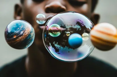 Child Blowing Bubbles Resembling Planets