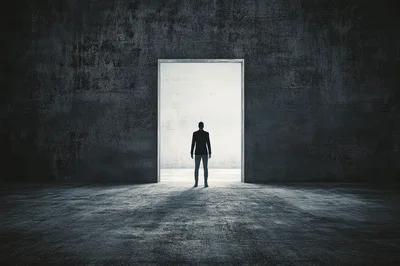 Silhouette Of A Man Standing Before A Bright Doorway