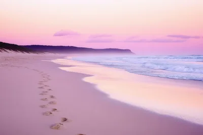 Footprints On A Serene Beach At Sunset