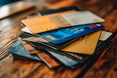 Stack of Various Credit Cards on Wooden Table