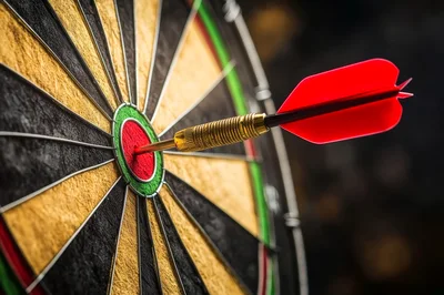Red Dart Hitting The Bullseye On A Dartboard