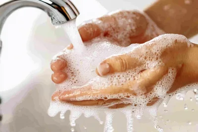 Person Washing Hands With Soap Under Running Water
