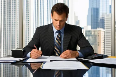 Professional Businessman Signing Documents In A High Rise Office