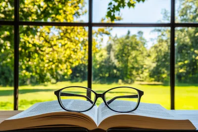 Open Book With Reading Glasses On A Window Sill