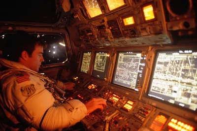 Astronaut Operating Space Shuttle Cockpit Controls