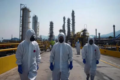 Industrial Workers In Hazmat Suits Walking At Refinery