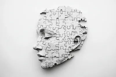 White Puzzle Pieces Forming A Human Face Profile