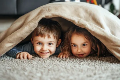 Young Children Playing Under A Blanket Fort