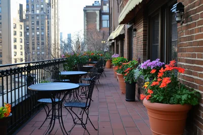 Outdoor Terrace With Potted Flowers And Bistro Tables