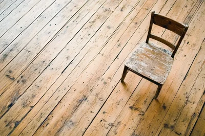 Single Weathered Wooden Chair On Rustic Floorboards