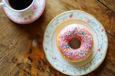 Pink Frosted Donut With Sprinkles On A Vintage Plate