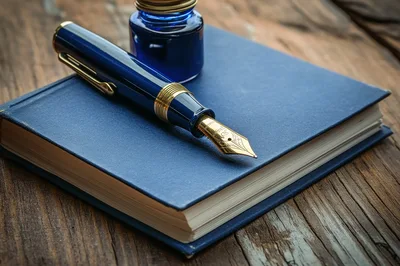 Blue Fountain Pen and Inkwell on a Journal