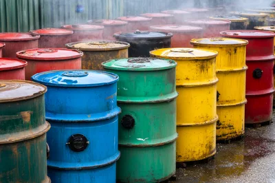 Industrial Metal Barrels Steaming In Outdoor Storage Yard