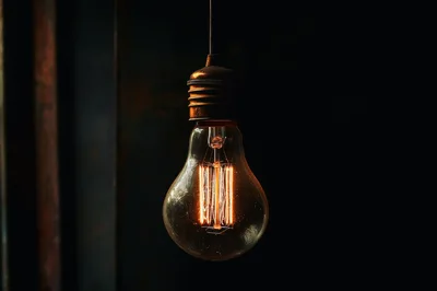 Vintage Edison Light Bulb Glowing In Dark Room