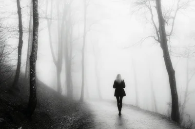 Woman Walking Alone On A Foggy Forest Path