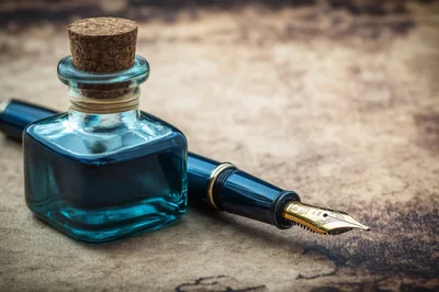 Fountain Pen And Blue Ink Bottle On Vintage Paper