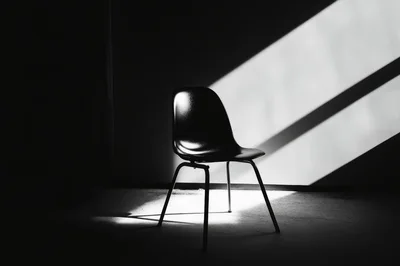 Minimalist Black Chair In Dramatic Light And Shadow