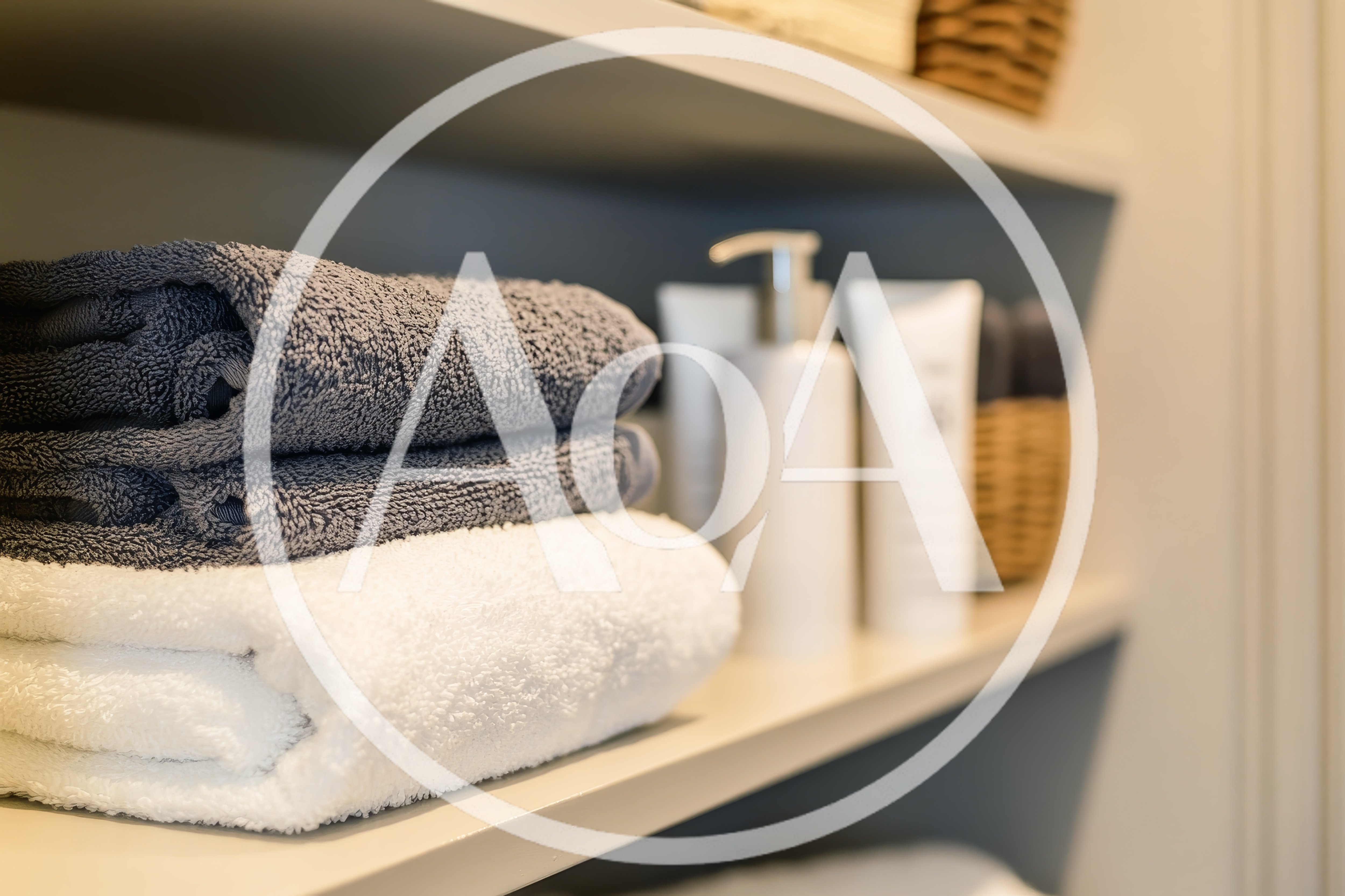 Stacked Towels And Toiletries On Bathroom Shelf