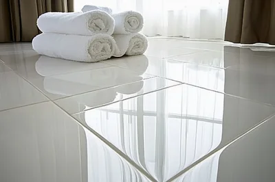 Stack Of White Rolled Towels On Glossy Tiled Floor