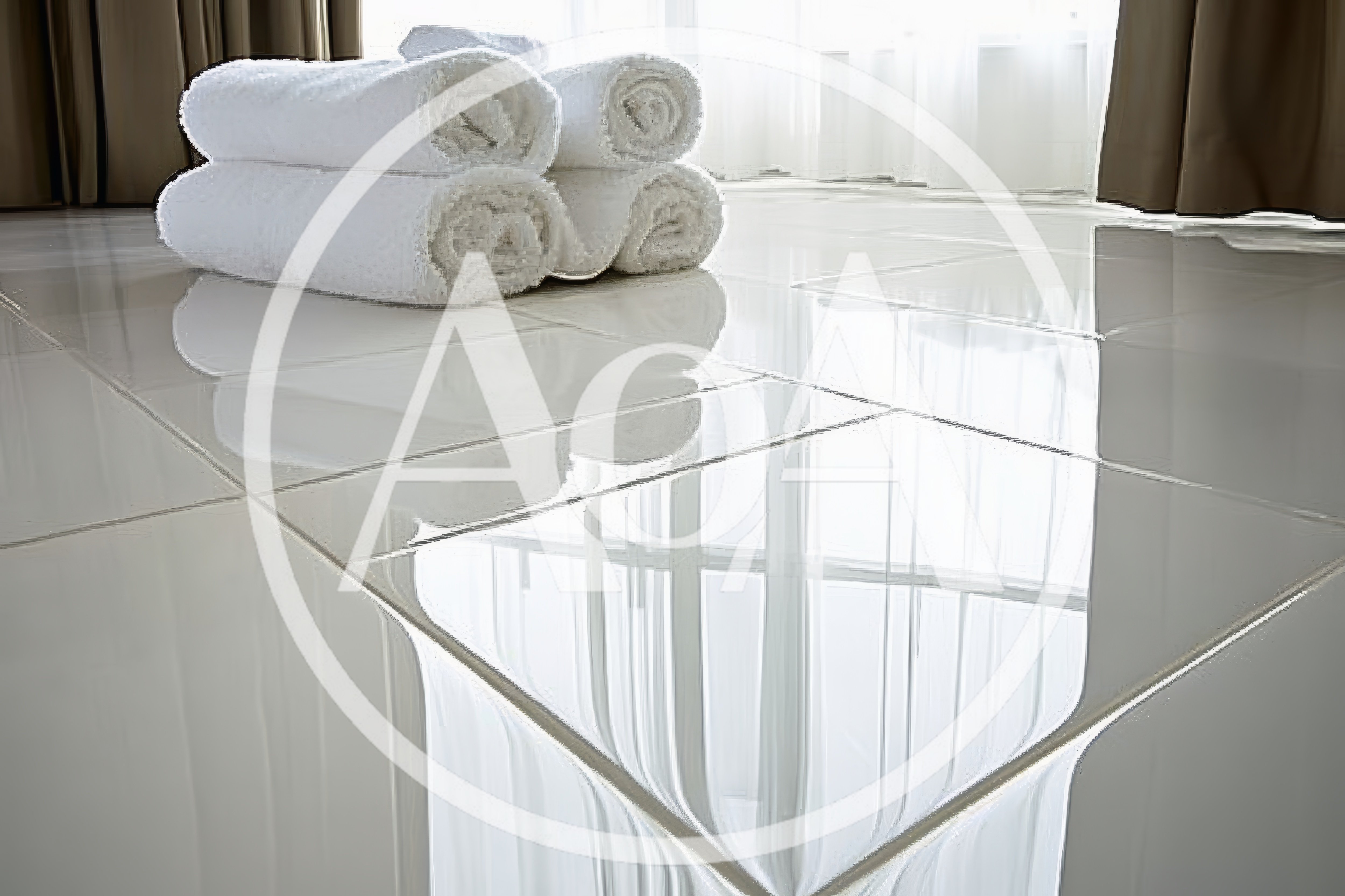 Stack Of White Rolled Towels On Glossy Tiled Floor