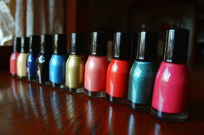 Row Of Colorful Nail Polish Bottles On Wooden Table
