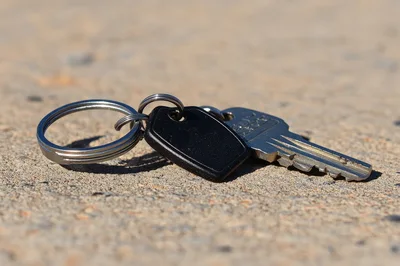 Single Metal Key With Black Tag On Concrete