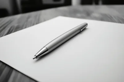 Silver Ballpoint Pen Resting On Blank White Paper