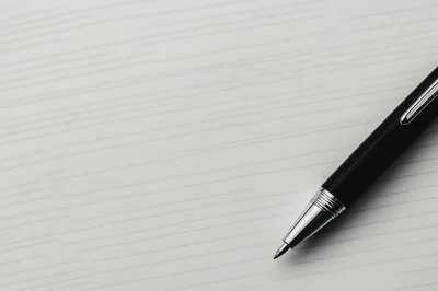Black Rollerball Pen Resting On White Textured Surface