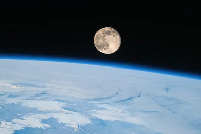Full Moon Rising Above Earth Atmosphere