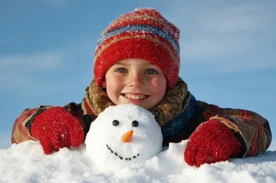 Happy Child Playing With A Small Snowman