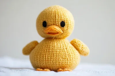 Knitted Yellow Duckling Toy On White Background