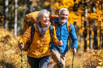 Active Senior Couple Hiking Together In Autumn Forest