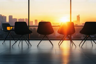 Empty Office Chairs Facing Sunset City Skyline
