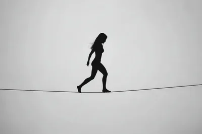 Silhouette Of A Woman Walking On A Tightrope