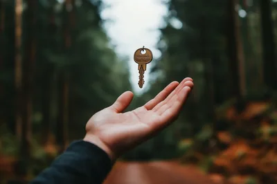 Hand Reaching For A Floating Key In Forest