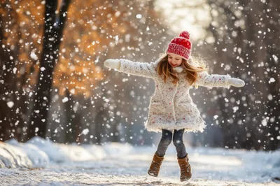 Happy Little Girl Jumping In Snowy Winter Park