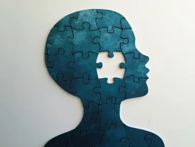 Human Head Silhouette Made Of Blue Jigsaw Puzzle Pieces