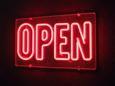 Red Neon Open Sign Glowing On Dark Wall