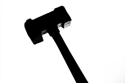 Silhouette Of A Heavy Sledgehammer Against White Background