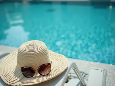 Sun Hat and Sunglasses on Poolside Lounge Chair