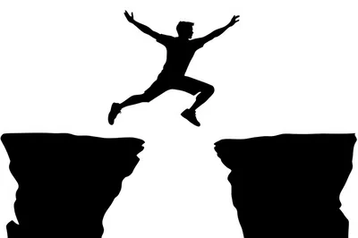 Silhouette Of A Man Jumping Across A Chasm
