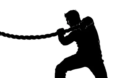 Silhouette Of A Man Pulling A Heavy Rope