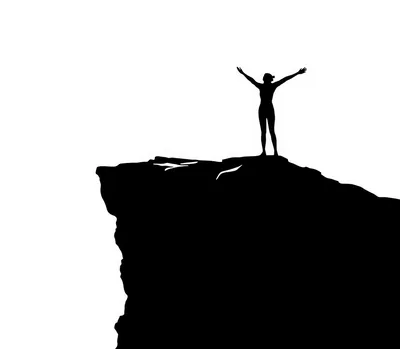 Silhouette Of A Person Standing On A Mountain Cliff