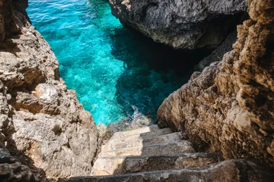 Stone Stairs Leading Down To Turquoise Sea