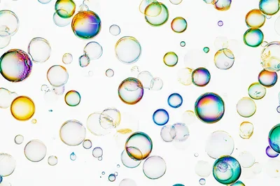 Floating Iridescent Soap Bubbles On White Background