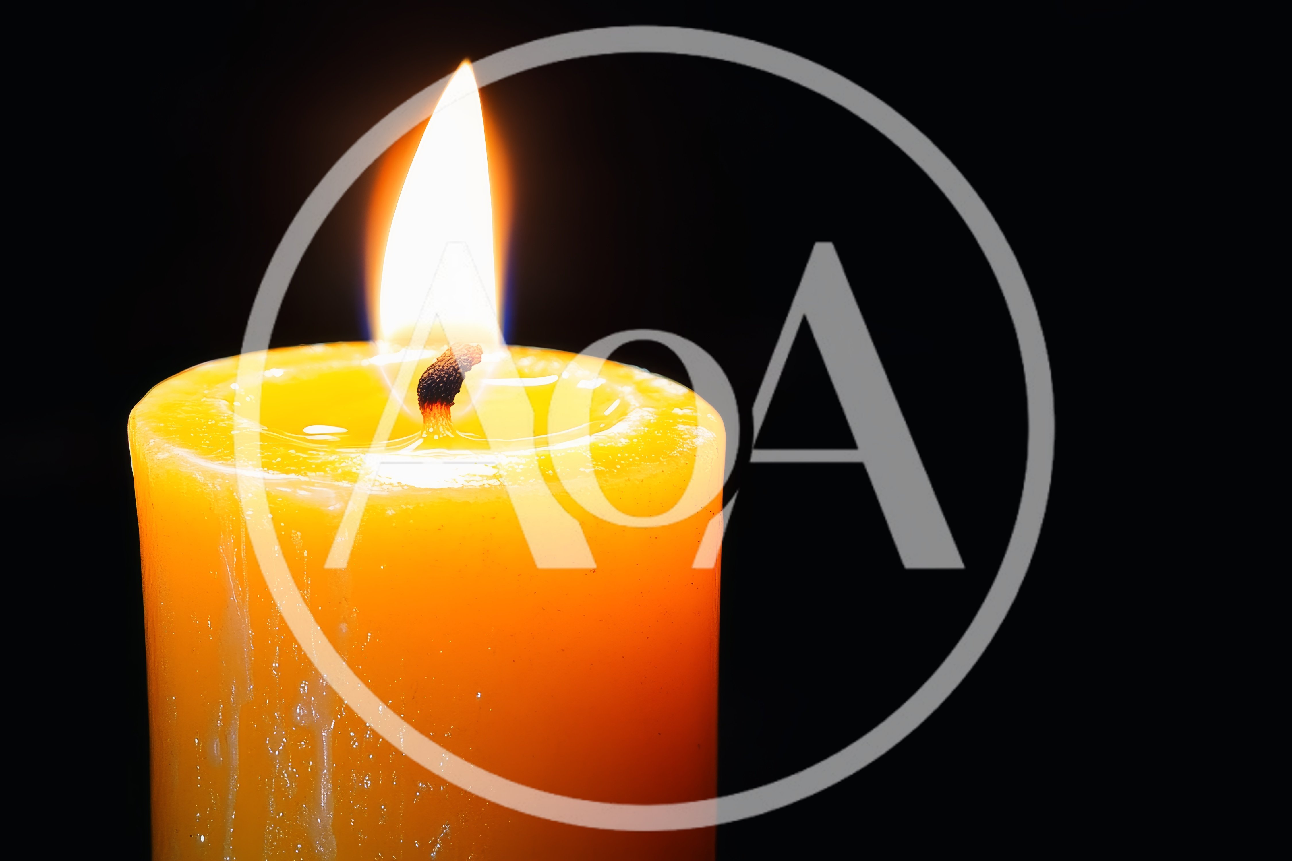 Burning Yellow Candle Against A Black Background