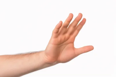 Male Hand Gesturing Stop Sign Against White Background