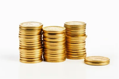 Three Stacks of Gold Coins on White Background